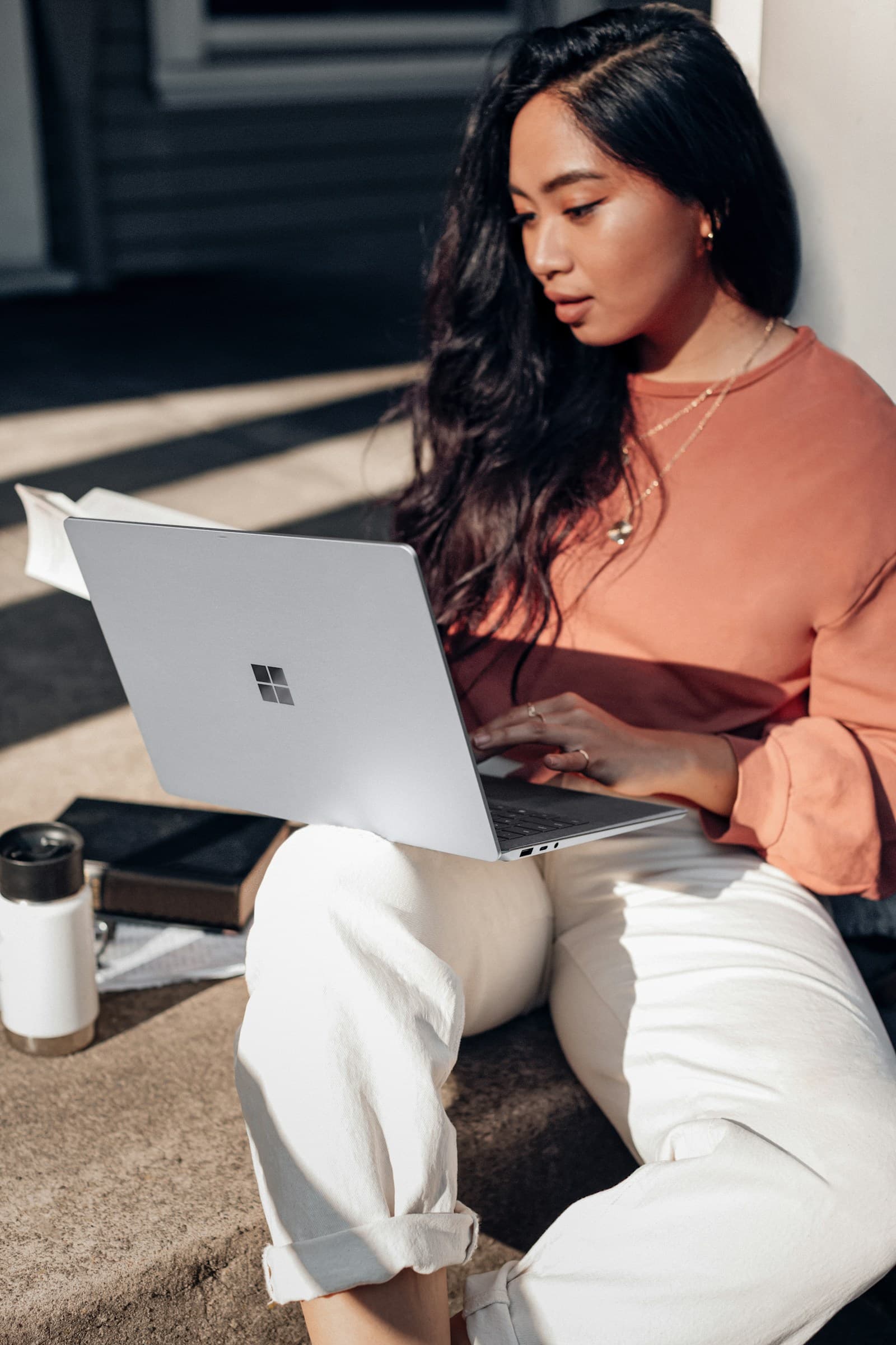A SaaS founder working on a laptop in morning sunlight